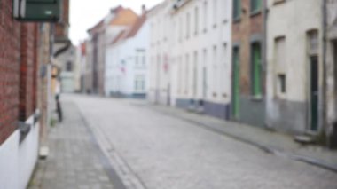 Avrupa 'daki dar kaldırım taşı sokağının arka planında birleşik tuğladan binalar var. Bruges sokağının bulanık video arkaplanı. 4k