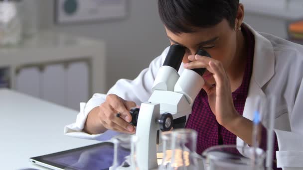 Médico Negro Mirando Través Del Microscopio Usando Tableta — Vídeos de Stock
