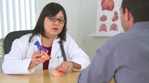 患者の心臓の状態を説明するアジアの医師 — ストック動画