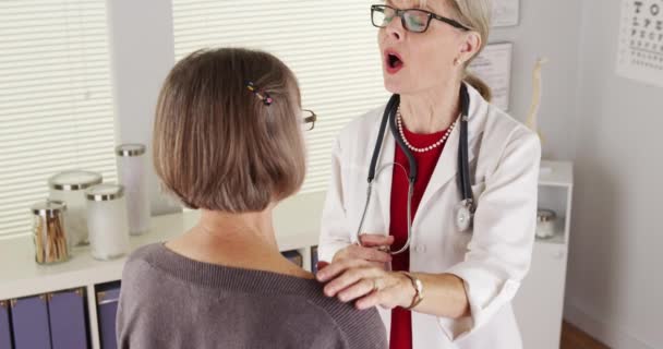患者の肩に話している年配の女性医師 — ストック動画
