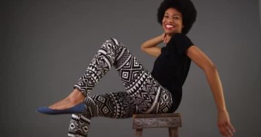 Sandalyenin üstünde dans mutlu siyah kadın