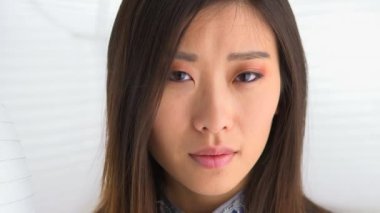 Çinli kadın kameraya bakıyor.