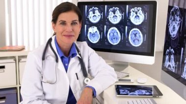 Doktor elinde röntgenlerle ofisinde oturuyor.
