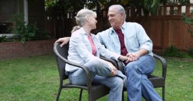 Olgun bir çift bahçede oturmuş konuşuyor.