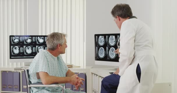 Oberarzt Erklärt Behinderten Älteren Patienten Röntgenbilder — Stockvideo