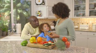 Afro-Amerikan ailesi mutfakta sebze doğruyor.