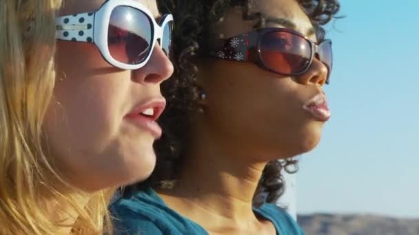 Twee Vrouwen Vrienden Een Zonnebril Blazen Kauwgom Het Strand — Stockvideo