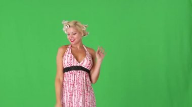 Saçında bigudileri olan genç bir kadın komik ve öpücükler saçıyor.