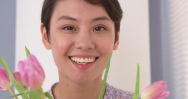 Lale ile gülümseyen çekici Çinli kadın