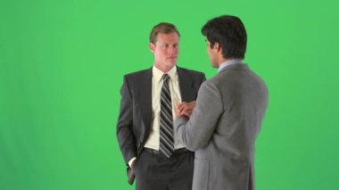 İki işadamı yeşil ekranda dikiliyor ve konuşuyor