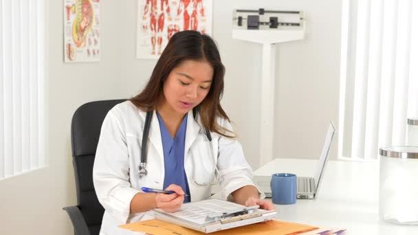女性アジアの医師は 机の上でクライアントと話す — ストック動画