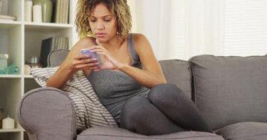 Siyah kadın kanepede Smartphone kullanarak