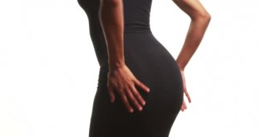 Dar siyah elbiseli bir kadının beyaz üzerinde yavaş çekimde dans edişinin dikiz görüntüsünü kapatın.