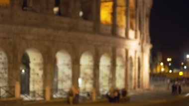 Odak noktasından çıkıp yürüyen turistler Avrupa 'daki antik harabeler. Roma 'da Roma Kolezyumu' nun önünde yürüyen insanların geçmişi bulanık. İtalya 'da.