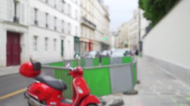 Küçük Avrupa caddesinde kırmızı scooter park etmiş. Şehir merkezinde park etmiş motosikletin odak alanı dışında