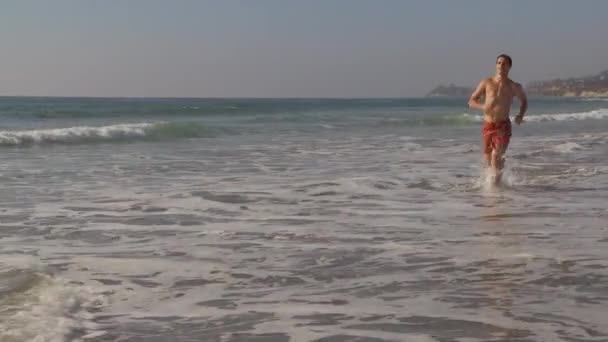 Joven Corriendo Por Playa Del Océano — Vídeos de Stock