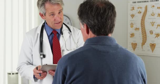 Doctor Senior Haciendo Preguntas Pacientes Ancianos Consultorio — Vídeos de Stock