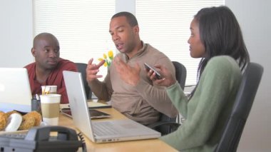 Çalışkan Afrikalı iş ortaklarından oluşan bir ekip masada konuşuyor.