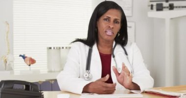 Kıdemli Afrikalı doktor kamerayla konuşuyor.