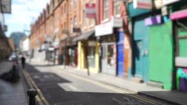 Bethnal Green mahallesindeki renkli mağazaların bulanık görüntüsü. Londra 'da dar cadde boyunca boyalı binaların açılı manzarası. 4k