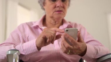 Yaşlı kadın mutlu bir şekilde akıllı telefon kullanıyor.