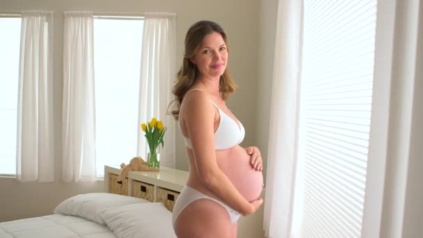 Gravid Kvinna Står Glatt Vid Fönstret — Stockvideo