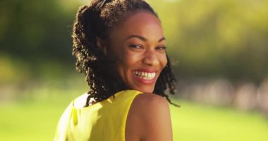 Parkta gülümseyen sevimli siyah kadın.