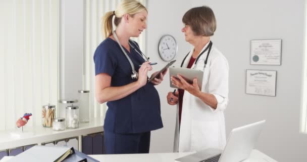 Médico Sênior Enfermeira Grávida Trocando Notas — Vídeo de Stock
