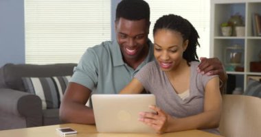 Mutlu genç siyah çift kullanarak tablet bilgisayar birlikte gülüyor