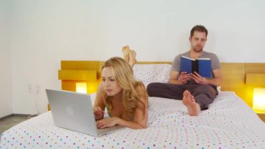 Dizüstü bilgisayar kullanan genç bir çift.