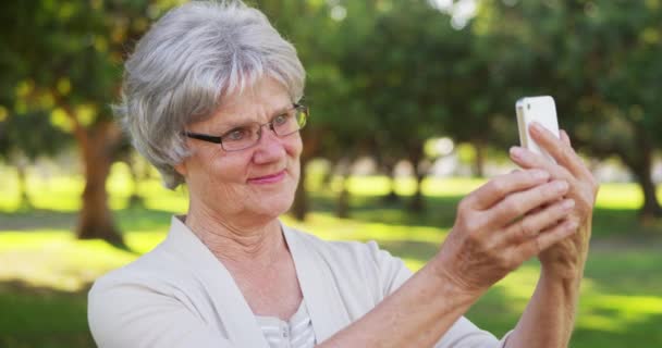 Ισχίου Γιαγιά Λαμβάνοντας Selfies Στο Πάρκο — Αρχείο Βίντεο
