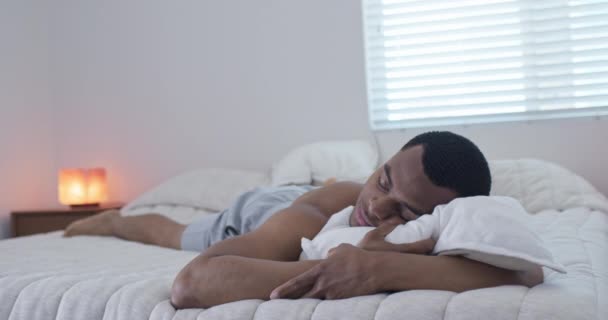アフリカ系アメリカ人の男が枕の上に寝そべっている １００万人の男が家で昼寝をしている 4Kスローモーションハンドヘルド — ストック動画