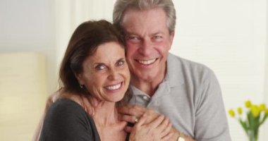 Tatlı üst düzey çift gülümseyen ve kameraya bakıyor