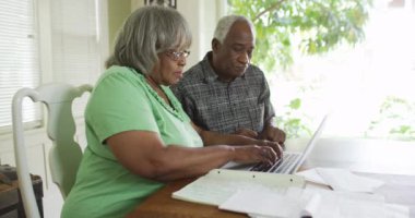 Olgun Afrikalı çift dizüstü bilgisayarında ödeme faturaları