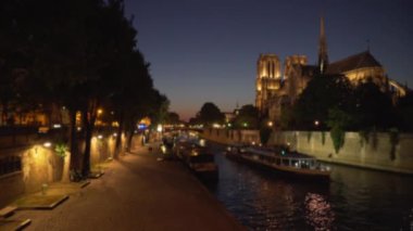 Paris 'teki Seine Nehri' nin karşısındaki Notre Dame Katedrali 'nin güzel manzarası. Gece sahnesi, tarihi Fransız tarihi simgesi. Tur teknesi de buradan geçiyor.