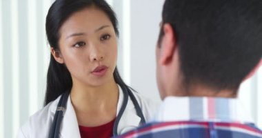 Asyalı Doktor hastaya konuşuyor