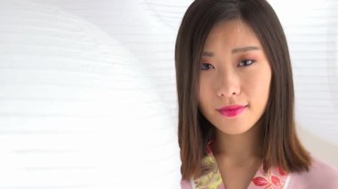 Çinli fenerlerin yanında duran Asyalı kadın.