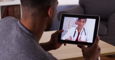 Afrikalı adam tabletten doktorla konuşuyor.