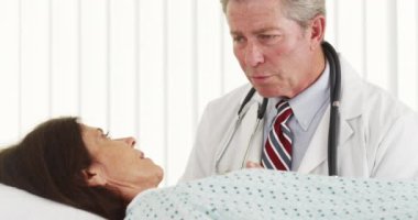 Kıdemli doktor konuşuyor ve hasta gülümseme yapma