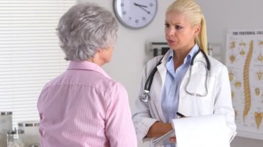 Doktor ve hasta muayene odasında konuşuyorlar.