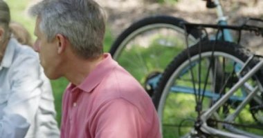 Bisiklet sürdükten sonra mola veren yaşlı çift.