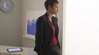 Siyahi iş kadını ofiste düşünüyor.