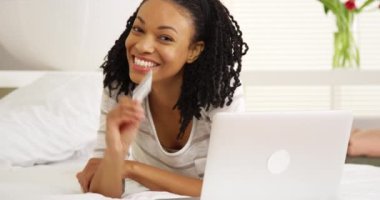 Laptop ve kredi kartı ile gülümseyen mutlu Afrikalı kadın