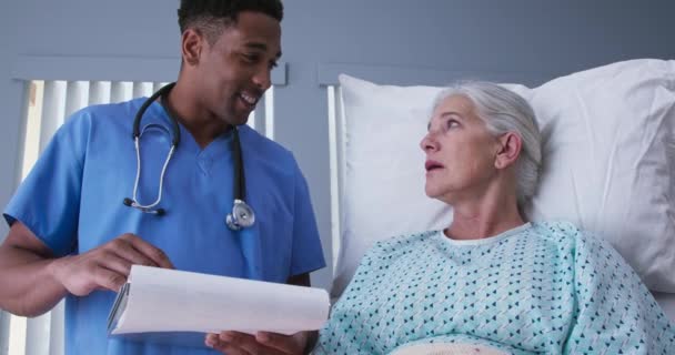 Enfermeira Sexo Masculino Millennial Leitura Médicos Notas Para Paciente Idoso — Vídeo de Stock