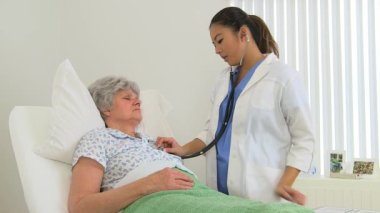 Kadın çok ırklı doktor hastasını muayene ediyor.