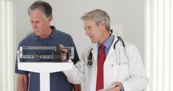 Kıdemli Doktor Yaşlı Hastayı Tartıyor — Stok video
