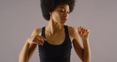 Siyah elbiseli Afrikalı kadın ağır çekimde dans ediyor.