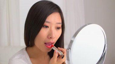 Çinli kadın ruj sürüyor.