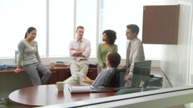 Genç iş arkadaşları ofiste iş tartışıyorlar.