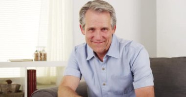 Kanepede gülümseyen olgun bir adam